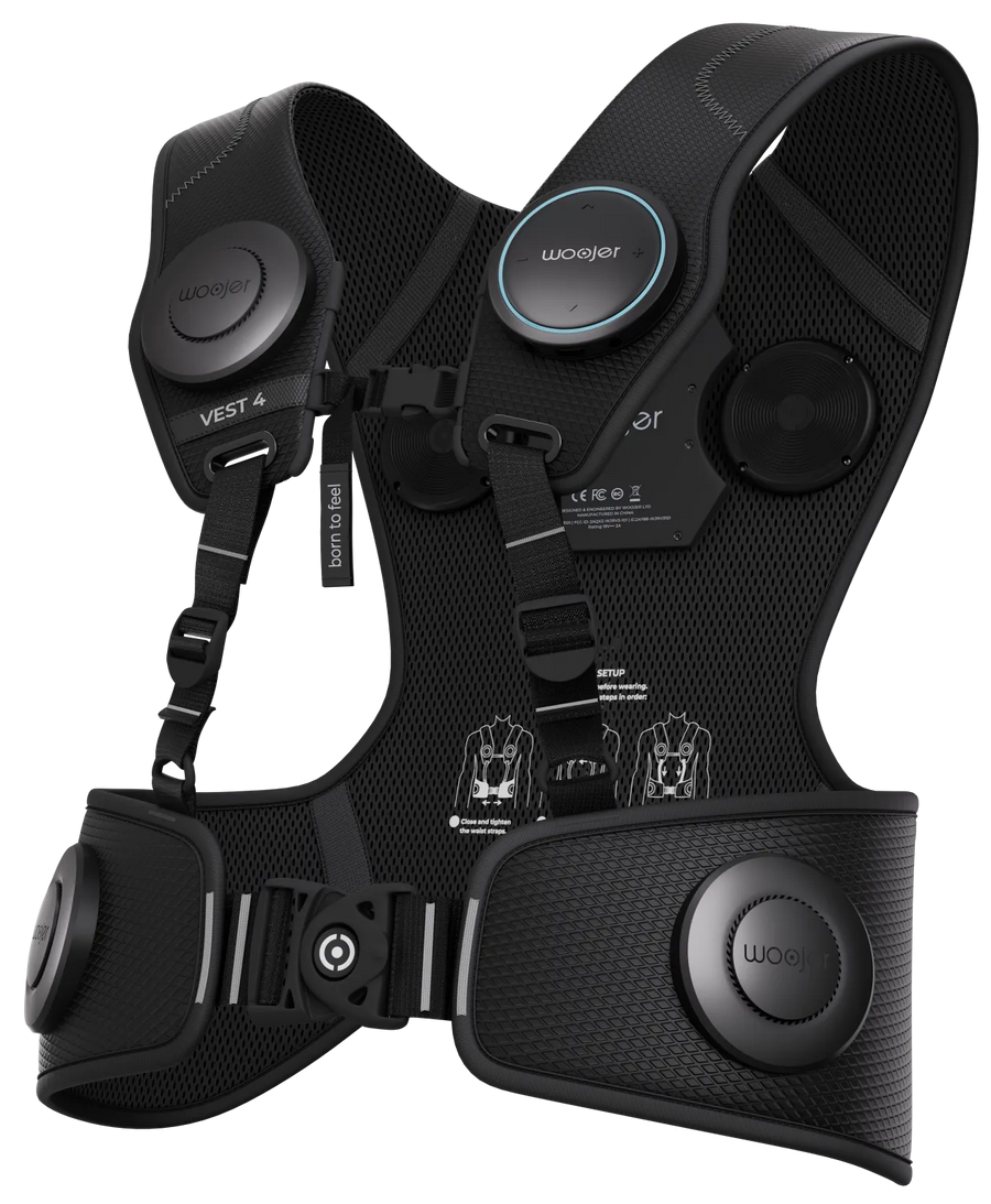 Woojer Vest 4, a black mesh haptic vest with round control units on the chest, shoulder, and waist.